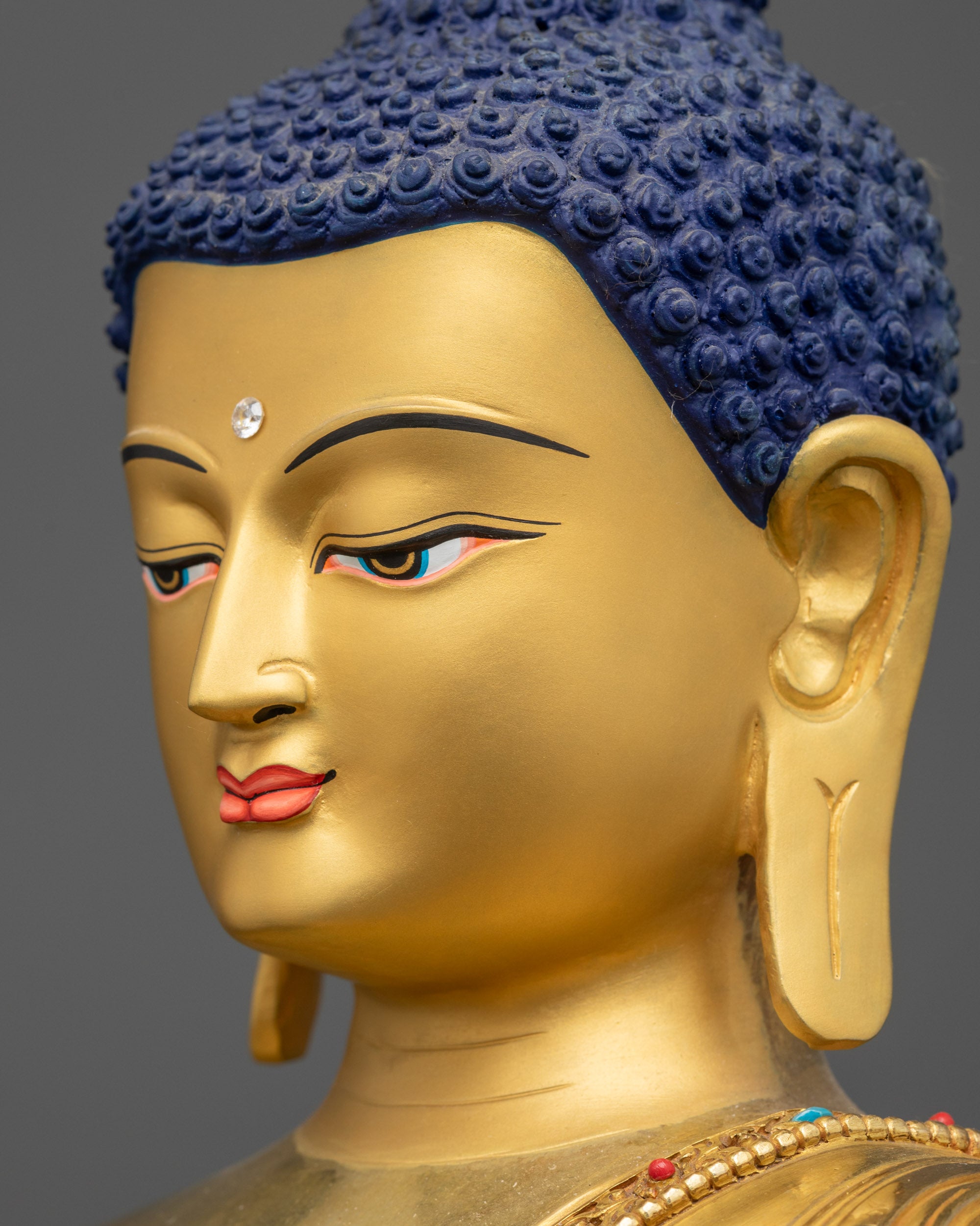 side close up face Suvarnabhadra Vimala statue gold-gilded serene expression
