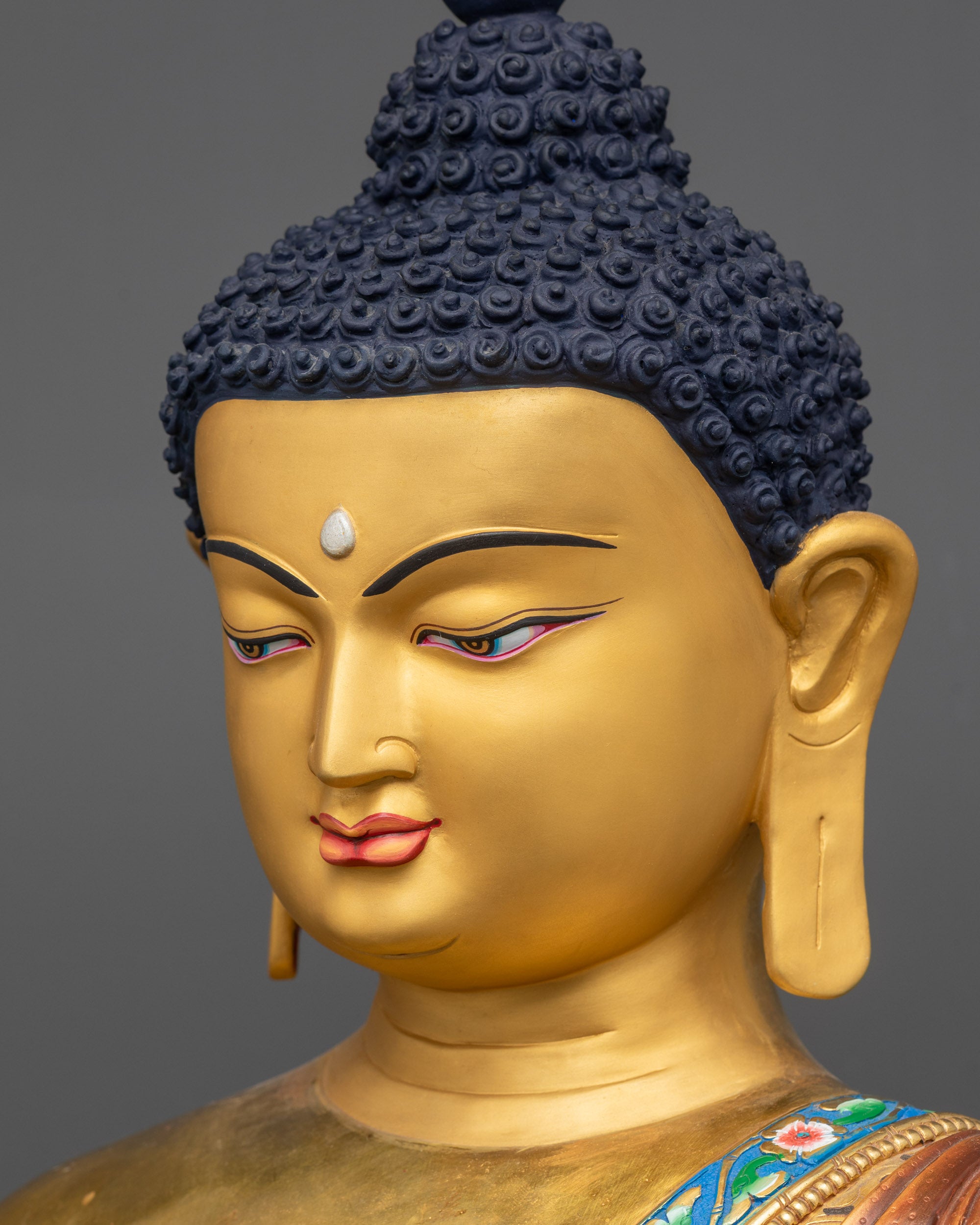 side close up face of Shakyamuni Buddha Statue with gold-gilded calm expression