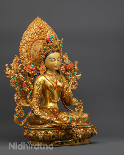 side view Green Tara seated in royal ease on lotus with halo and semi-precious stones
