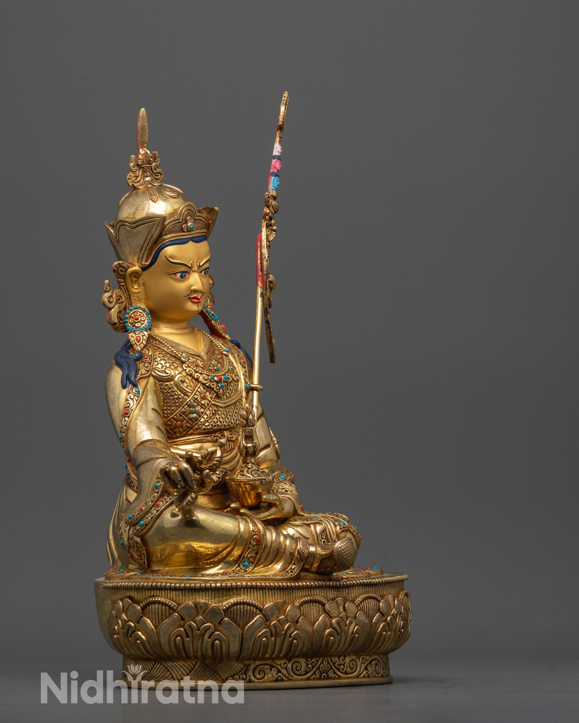 side view Padmasambhava statue gold gilded robe with khatvanga staff and detailed carvings
