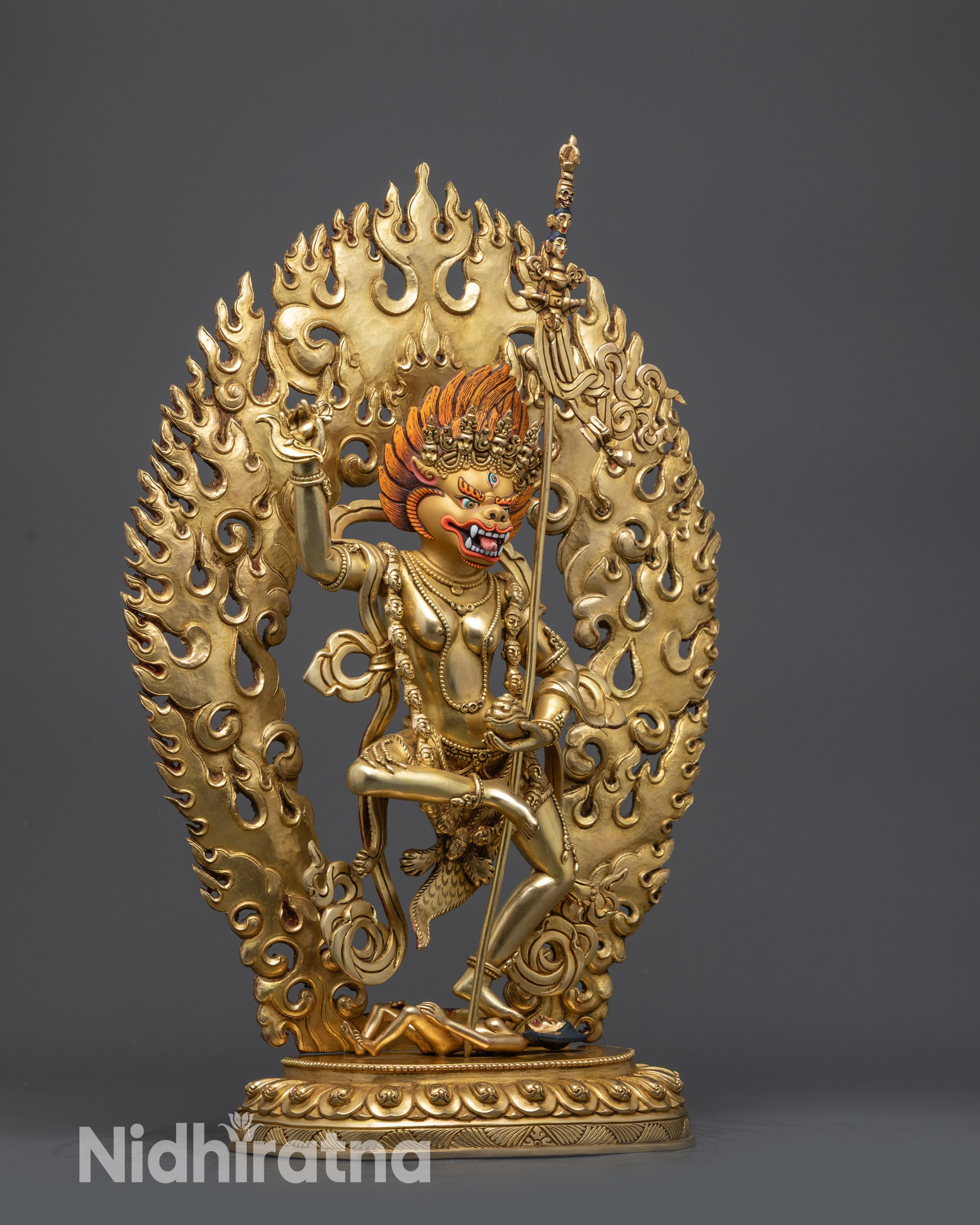 side view Simha Mukha statue holding kartika knife and khatvanga trident
