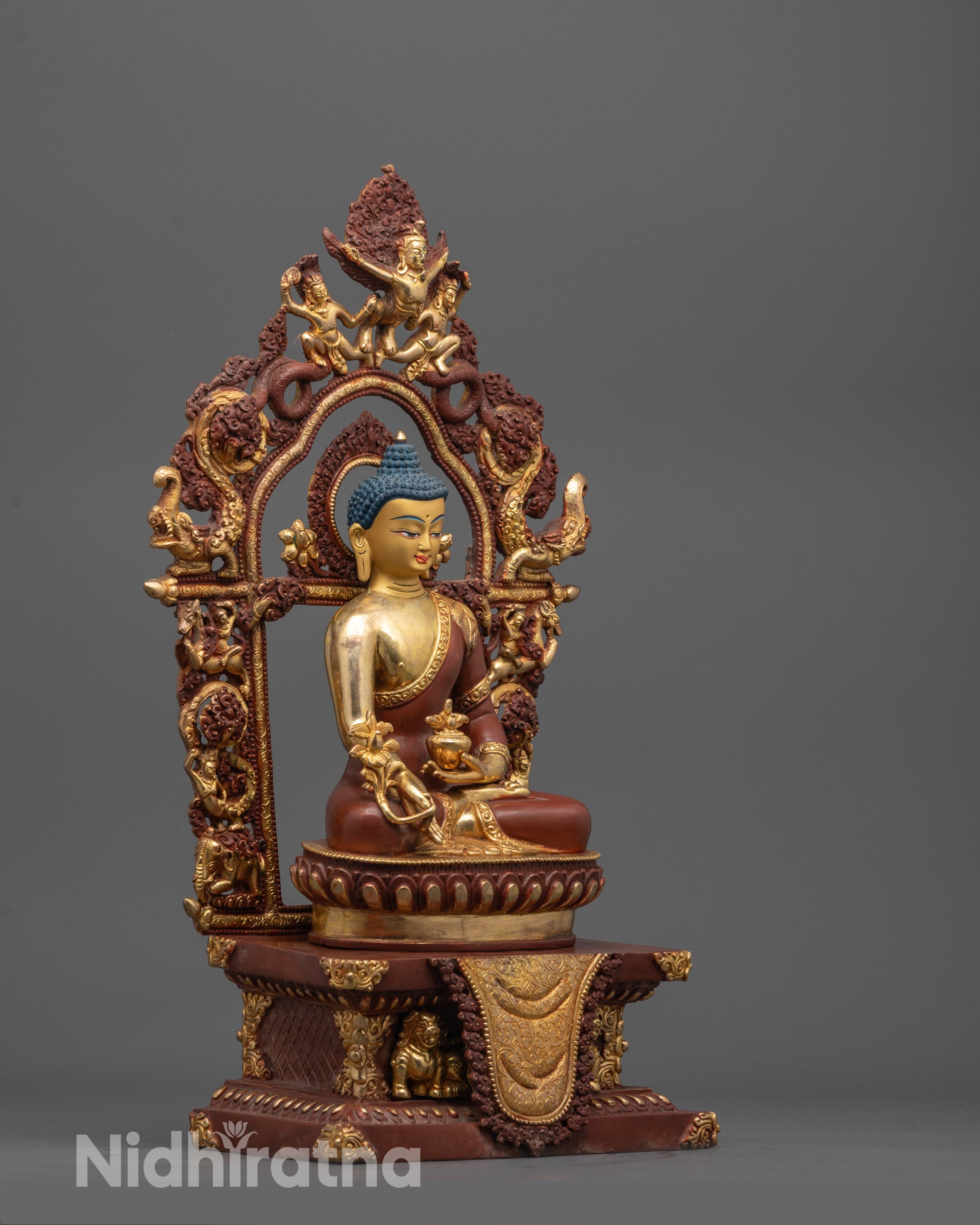 side view of Medicine Buddha statue showing gold-plated lotus seat and detailed copper robe