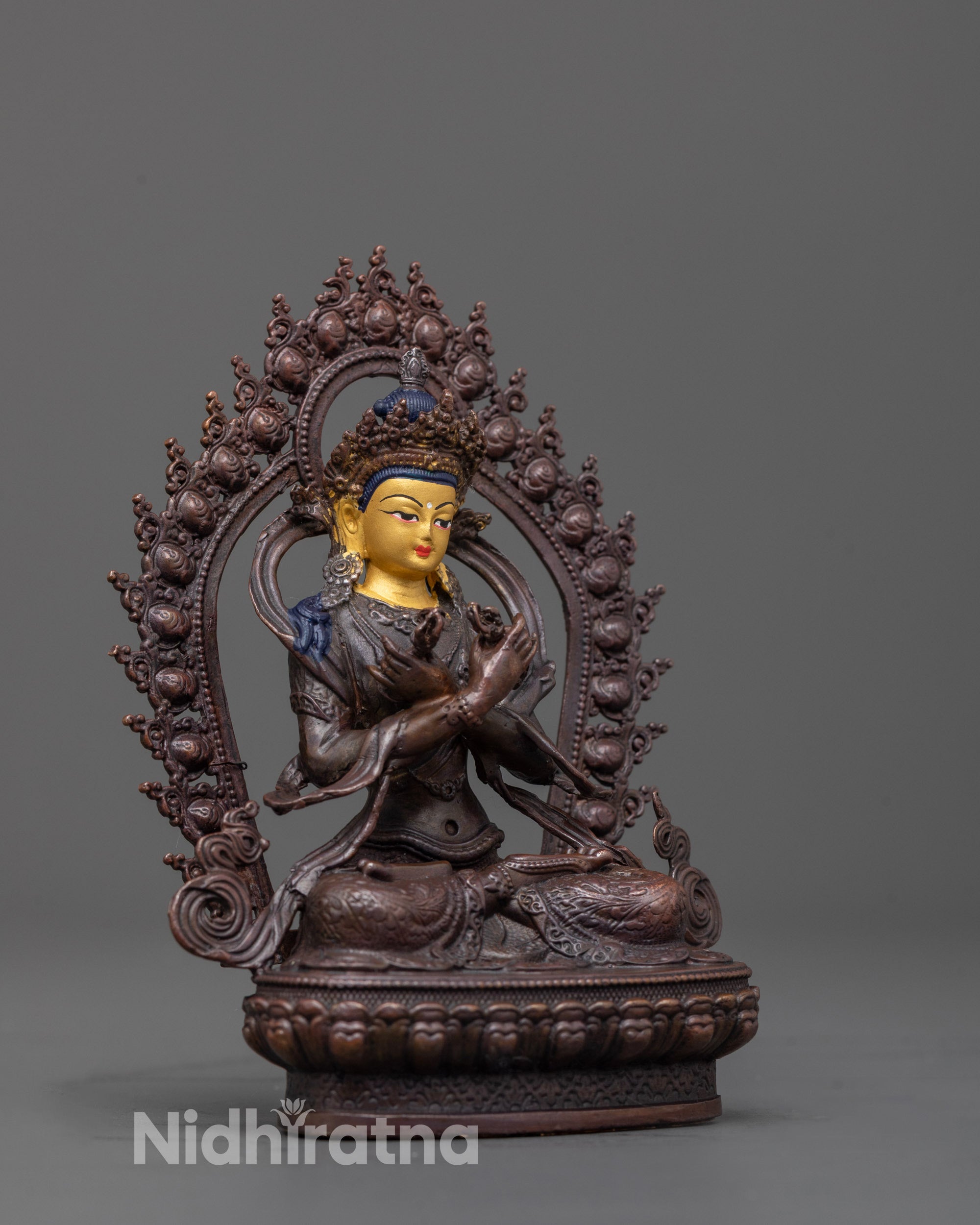 side view of Vajradhara statue with flowing robes and halo in oxidized copper finish