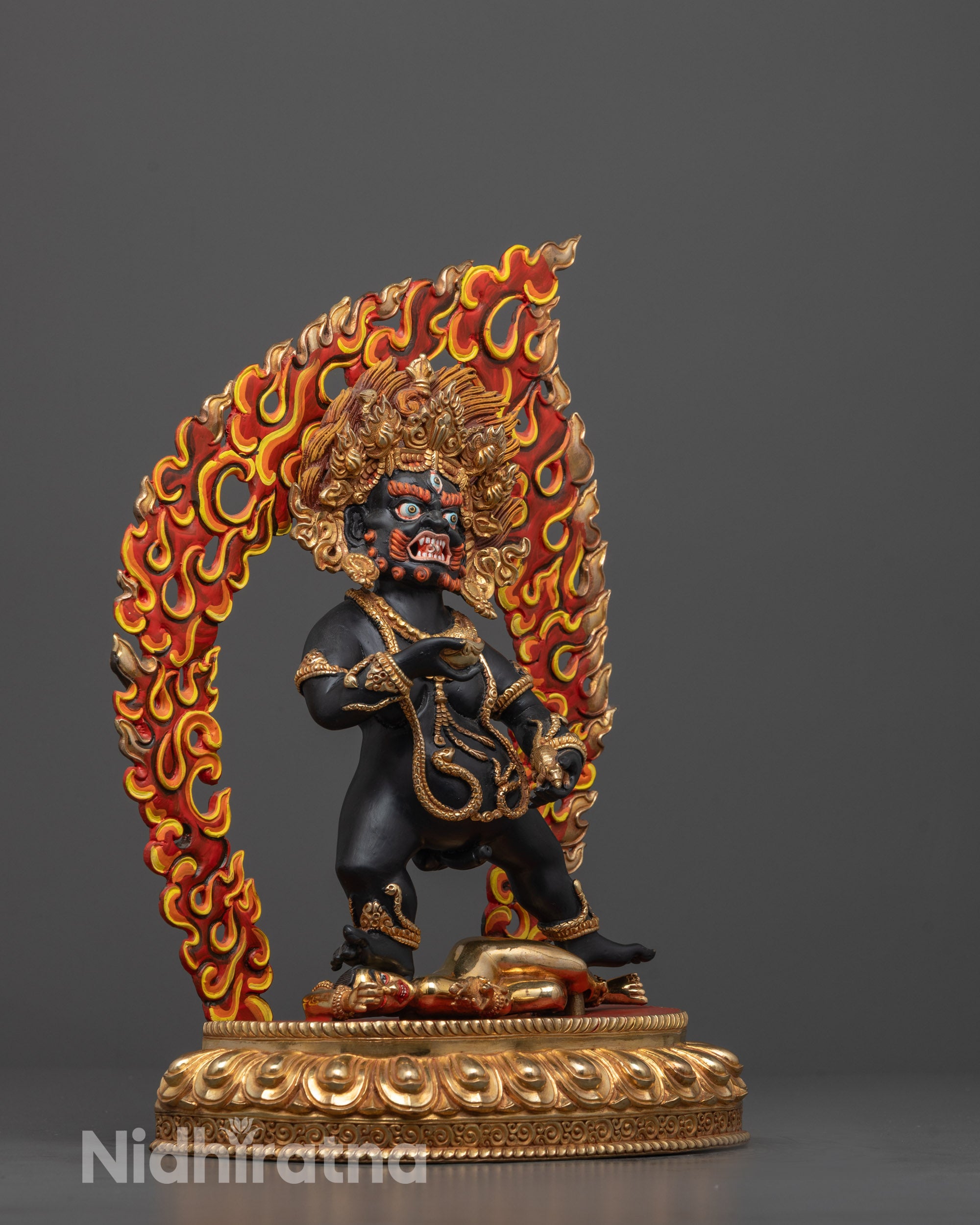 side view of black dzambhala on lotus base with halo and skull cup