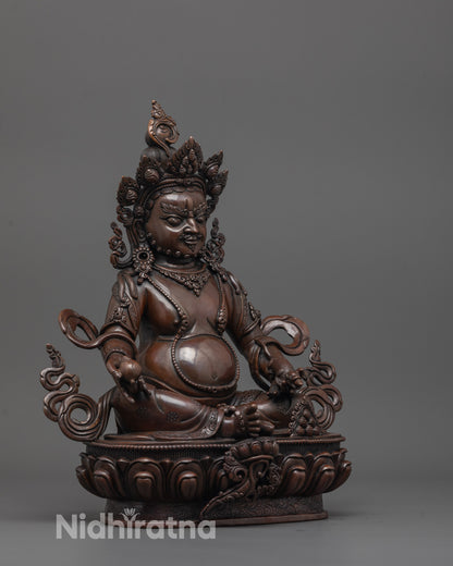 side view of dzambhala deity statue showcasing oxidized body and detailed lotus base carving