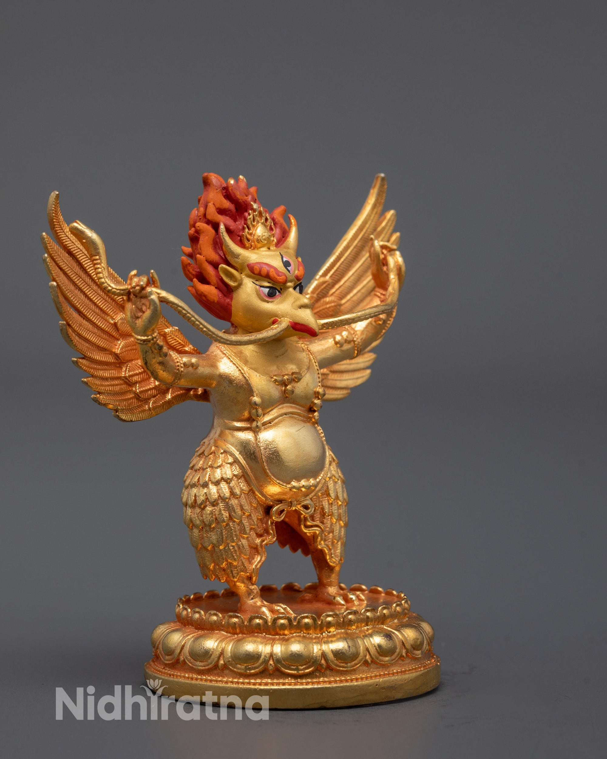side view of garuda statue showing sculpted wings and feathered lower body