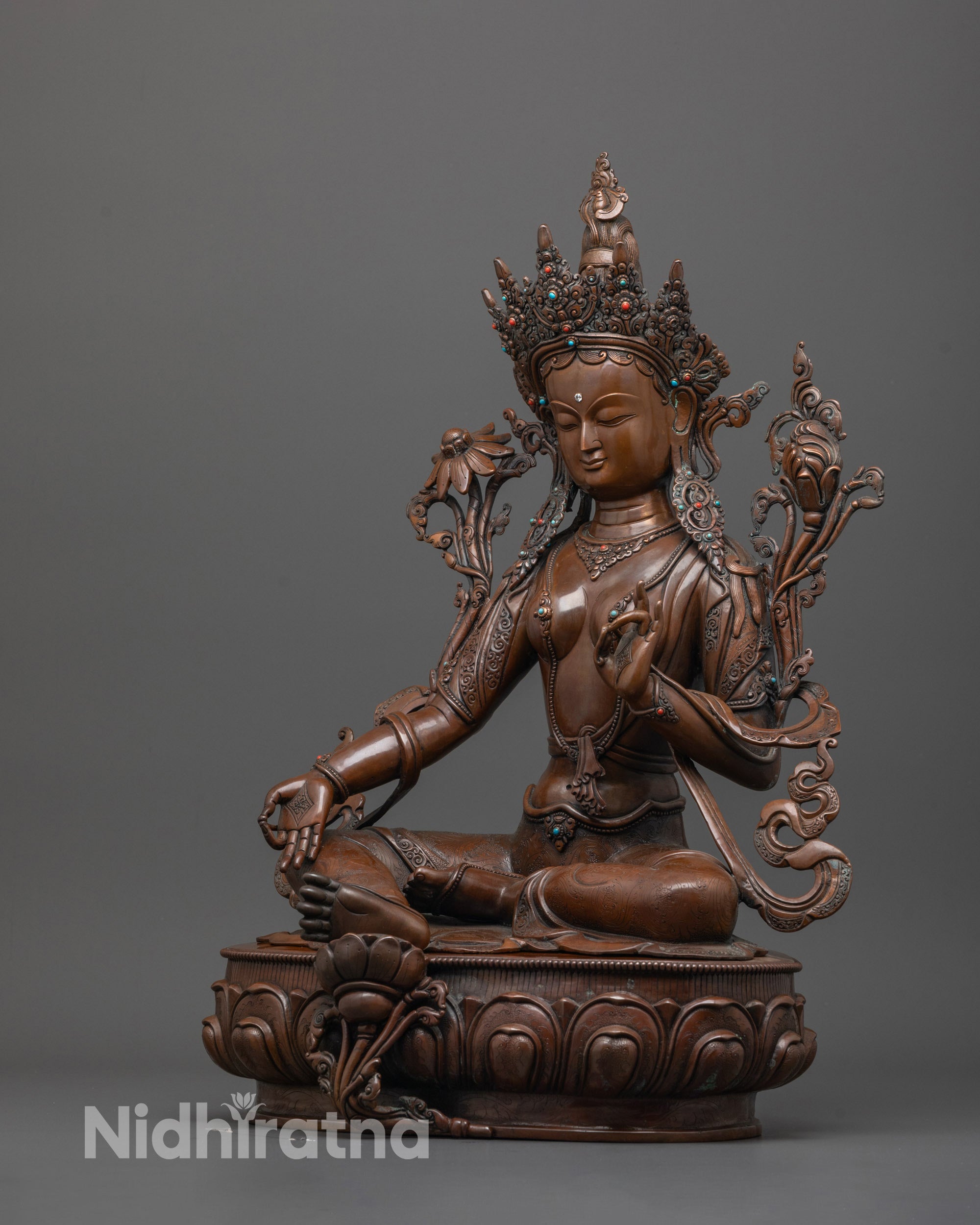 side view of green tara statue highlighting hand-carved lotus base and posture