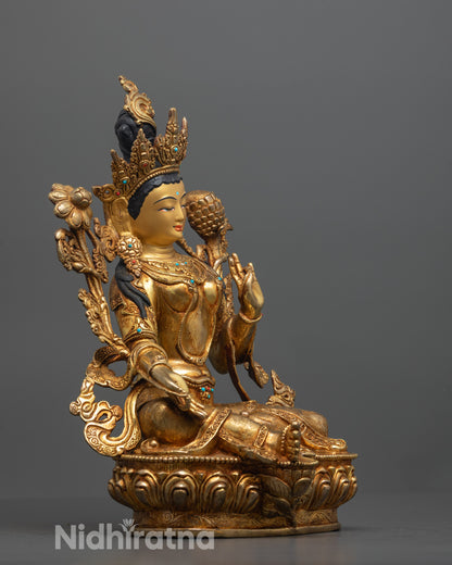 side view of green tara statue with vitarka mudra and utpala flower in graceful pose