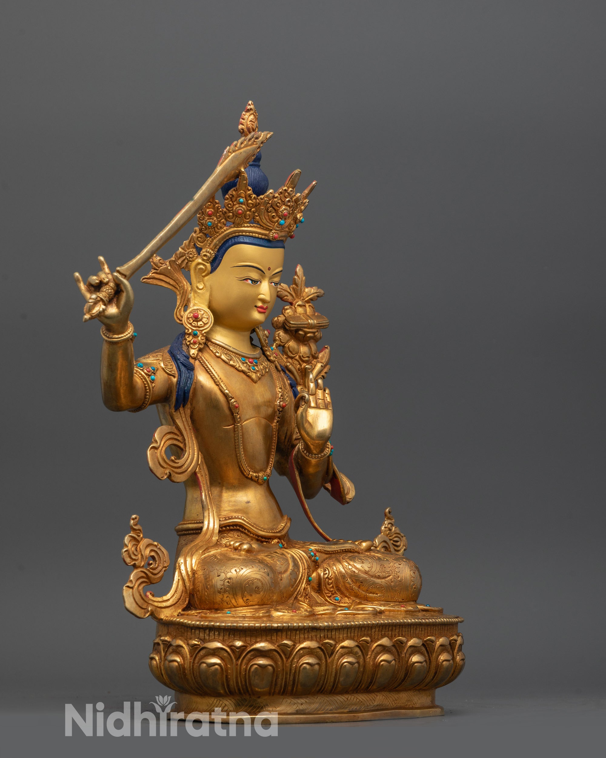 side view of manjushri statue holding sword utpala flower and scripture with intricate carvings