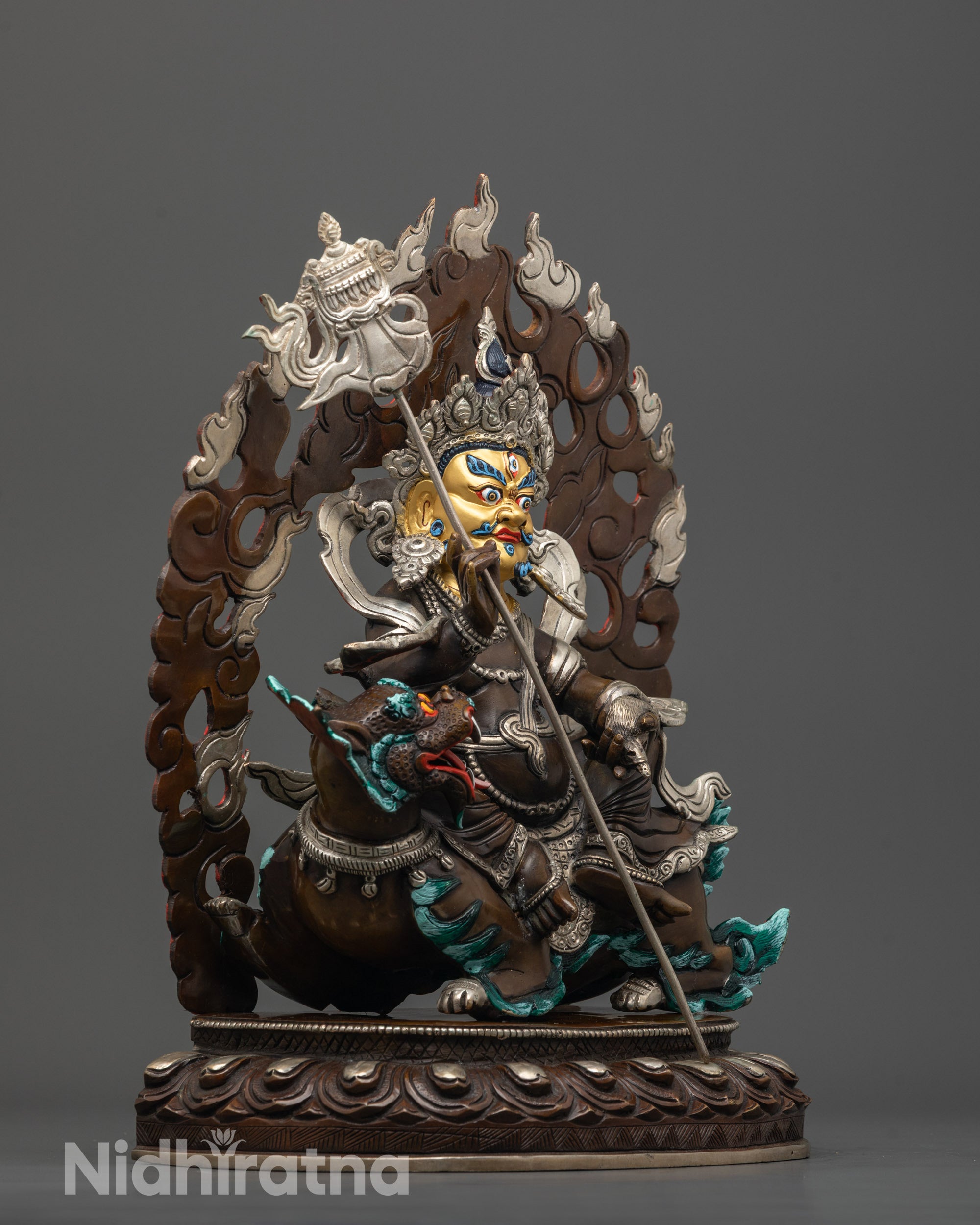side view of namtoshe statue with parasol mongoose and intricately carved crown details
