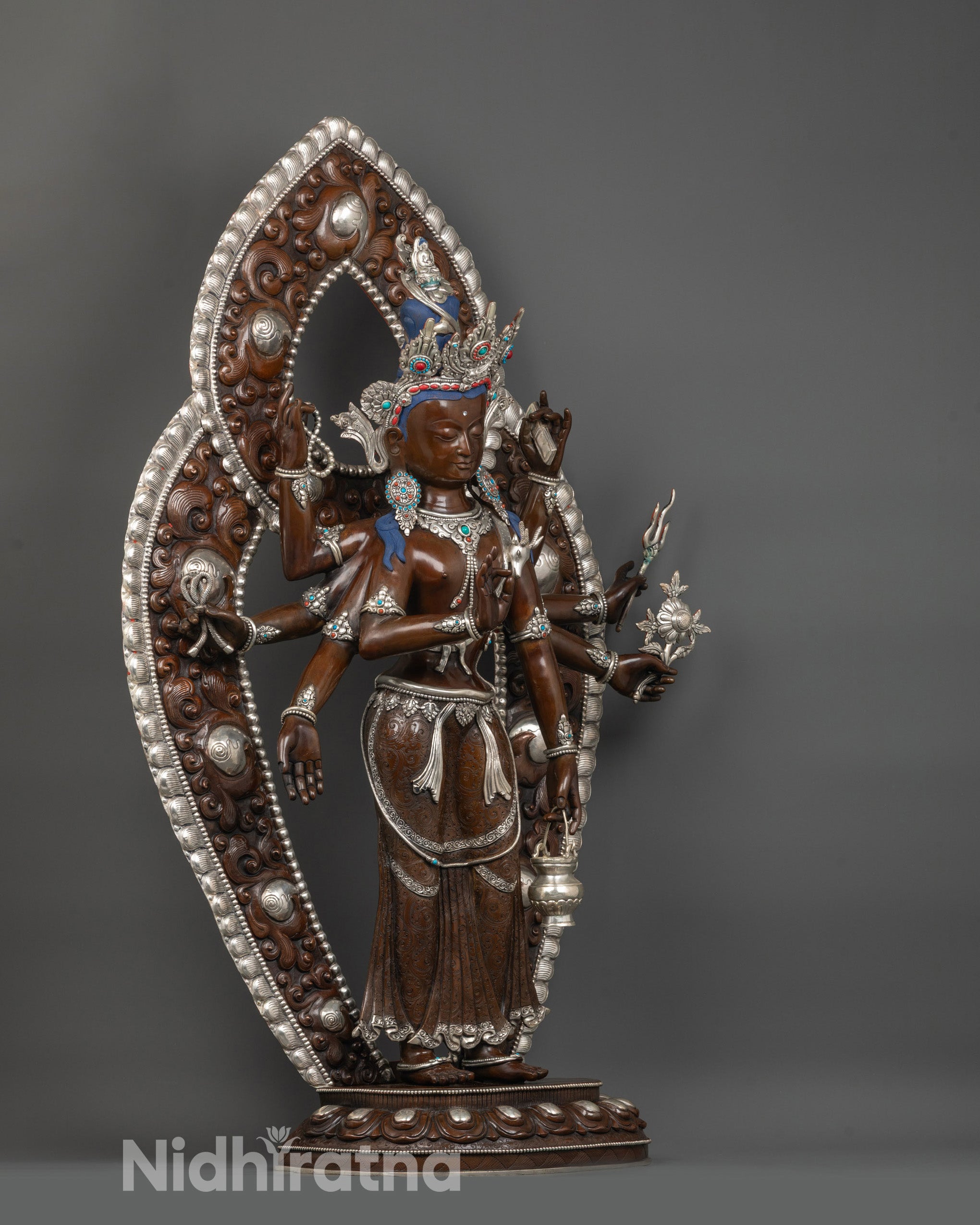 side view of oxidized amoghapasa lokeshvara statue with multiple arms holding sacred objects