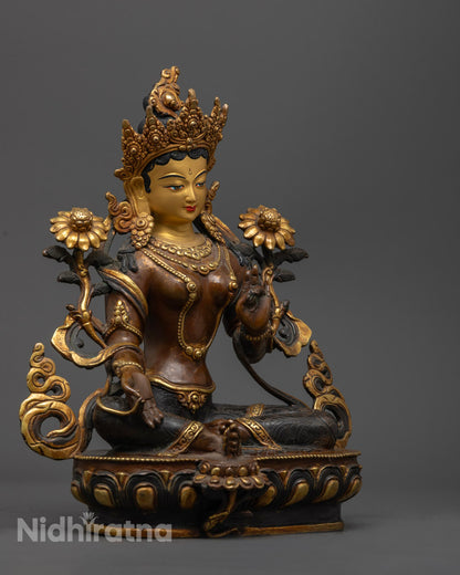side view of oxidized copper green tara statue holding utpala flower in royal ease pose