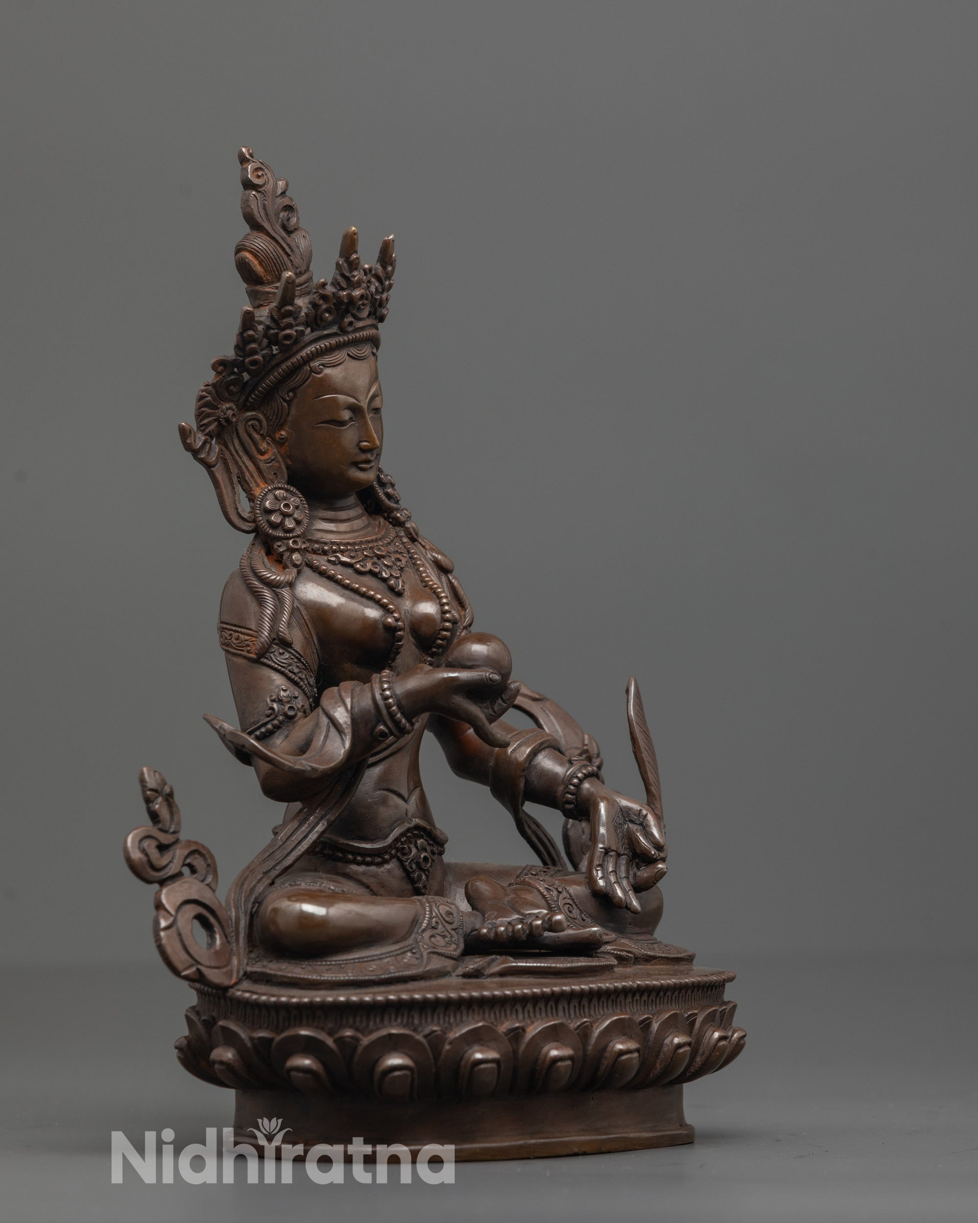 side view of oxidized ksitigarbha bodhisattva statue with carved robes and feathers