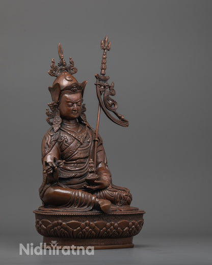 side view of padmasambhava statue with earthy hue body and flowing tirpatika robe