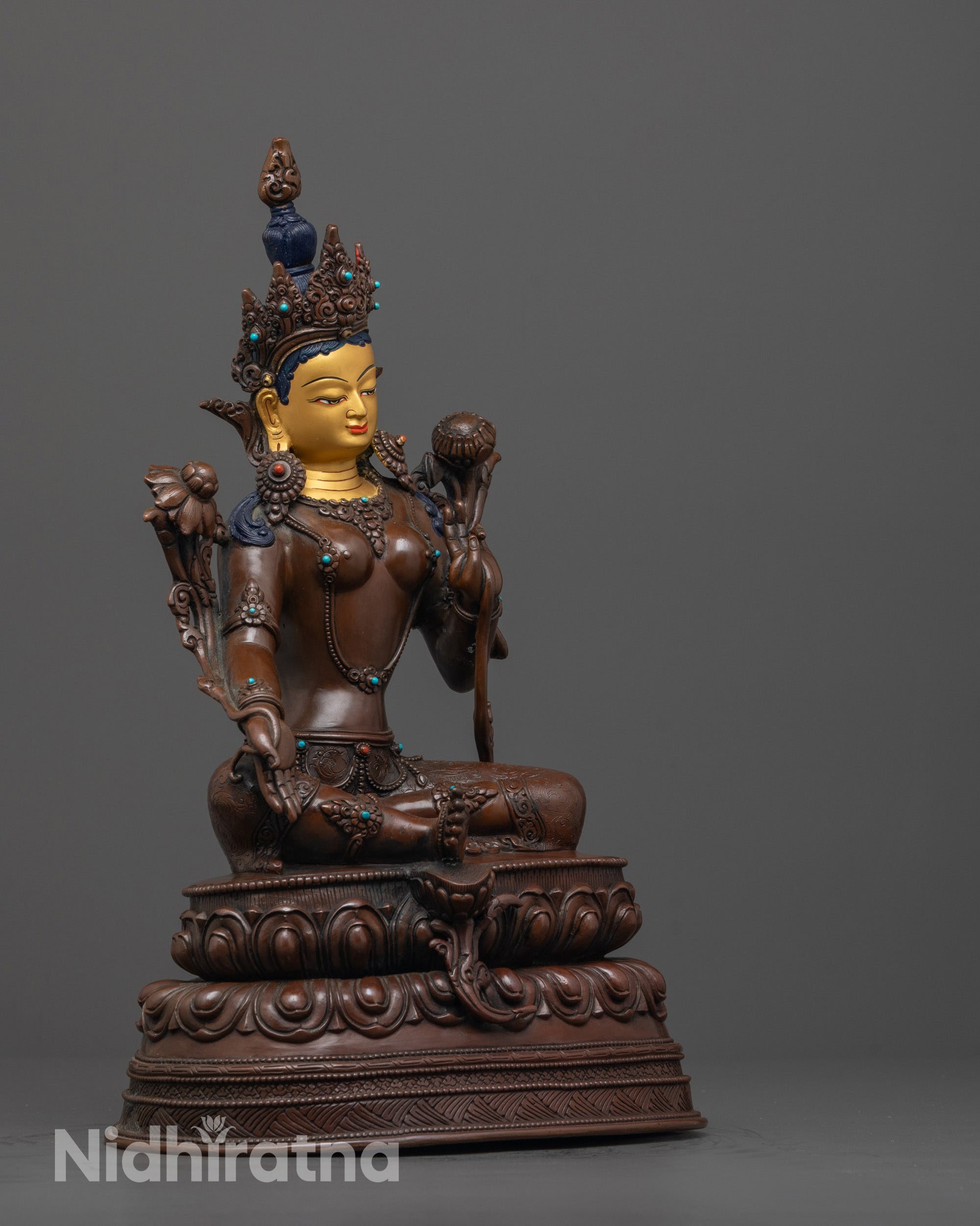 side view of syamatara statue in royal ease pose with carved robe and semi-precious stones