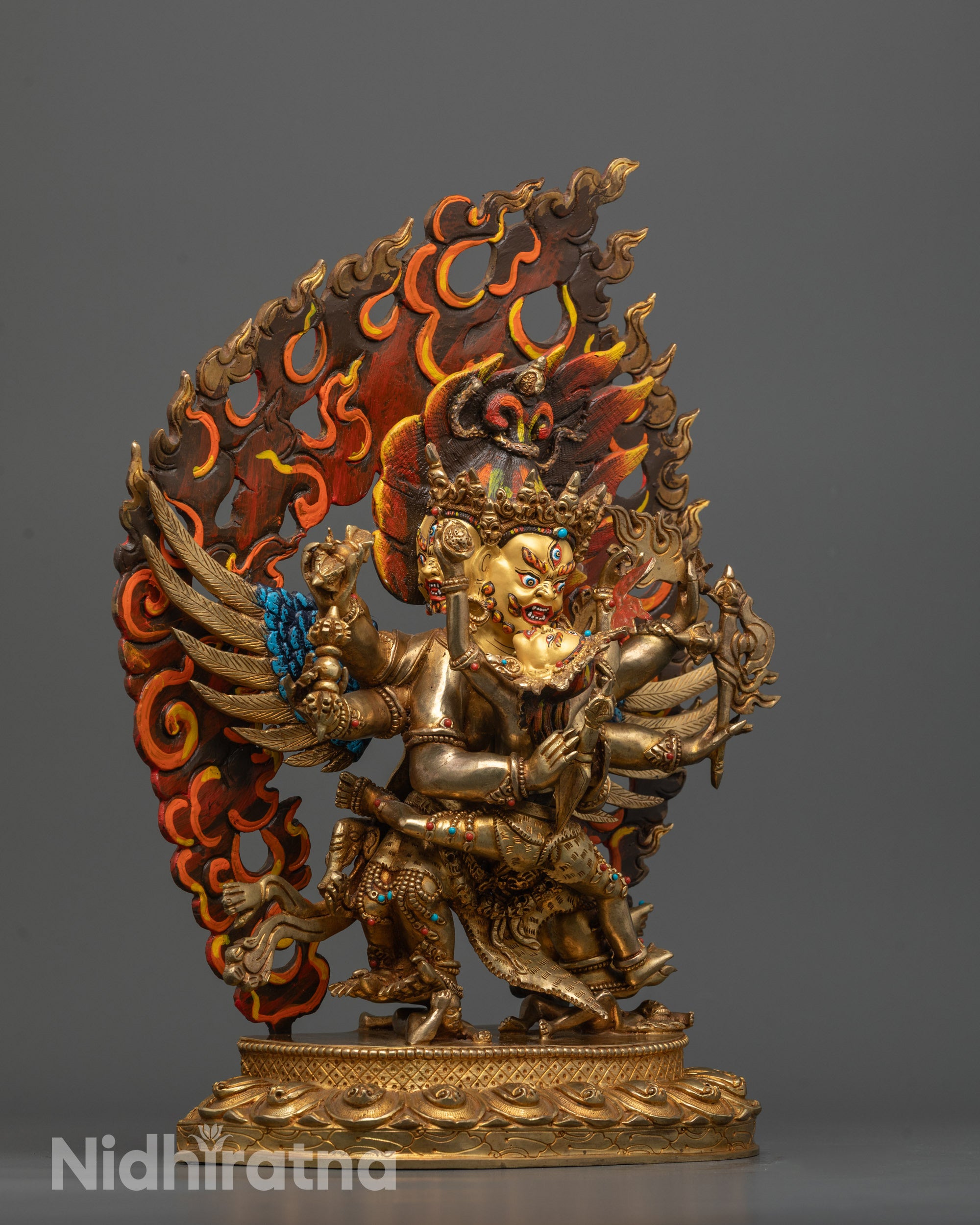 side view of vajrakilaya consort statue with three faces, six arms, and blazing halo
