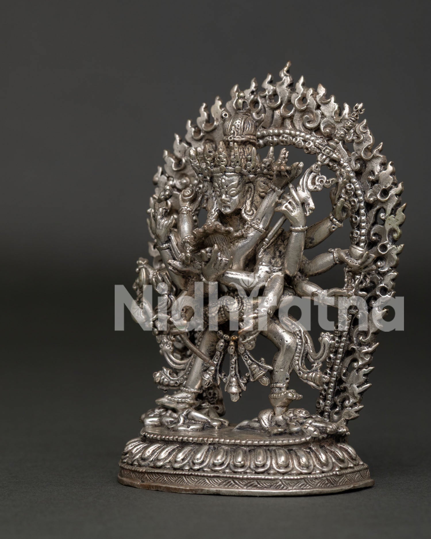 Silver plated Kalachakra statue with sacred ritual implements and blazing halo.