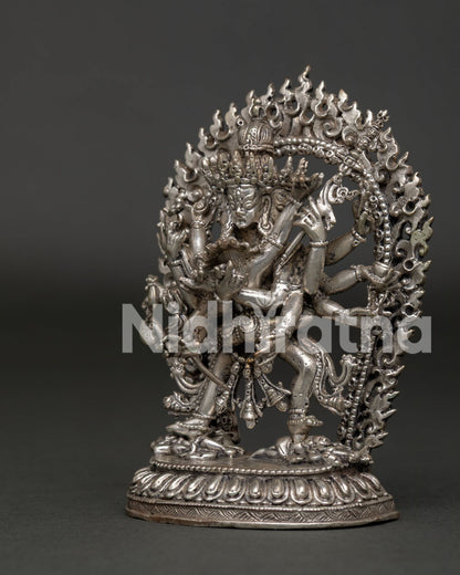 Silver plated Kalachakra statue with sacred ritual implements and blazing halo.