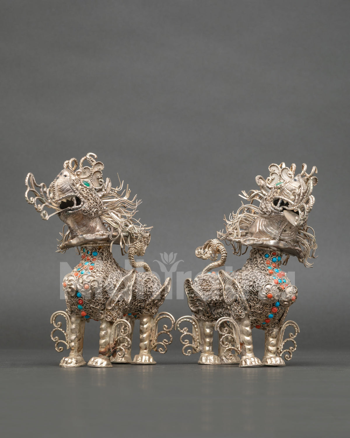 Silver plated Tibetan Snow Lion pair with intricate filigree artwork and semi precious stones.