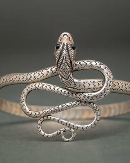 Silver snake bracelet featuring a sculpted serpent head with glossy black eyes