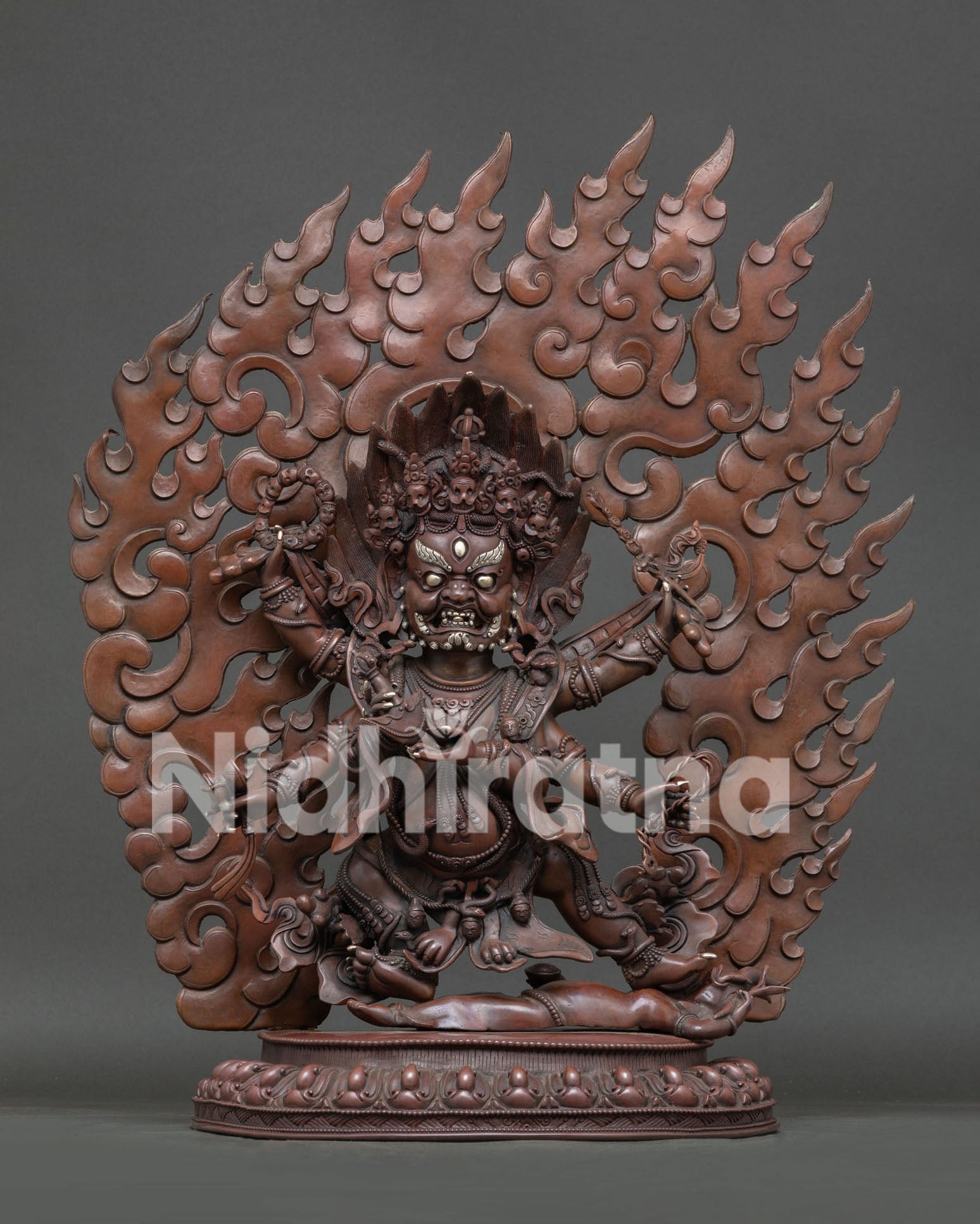Six Arm Mahakala Statue handcrafted in oxidized copper with silver details and lotus pedestal