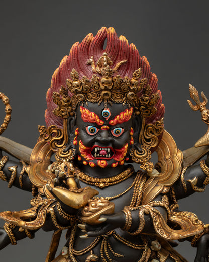 Six-armed Mahakala statue front close-up, showcasing the fierce facial expression, third eye, and intricate ornamental detailing.