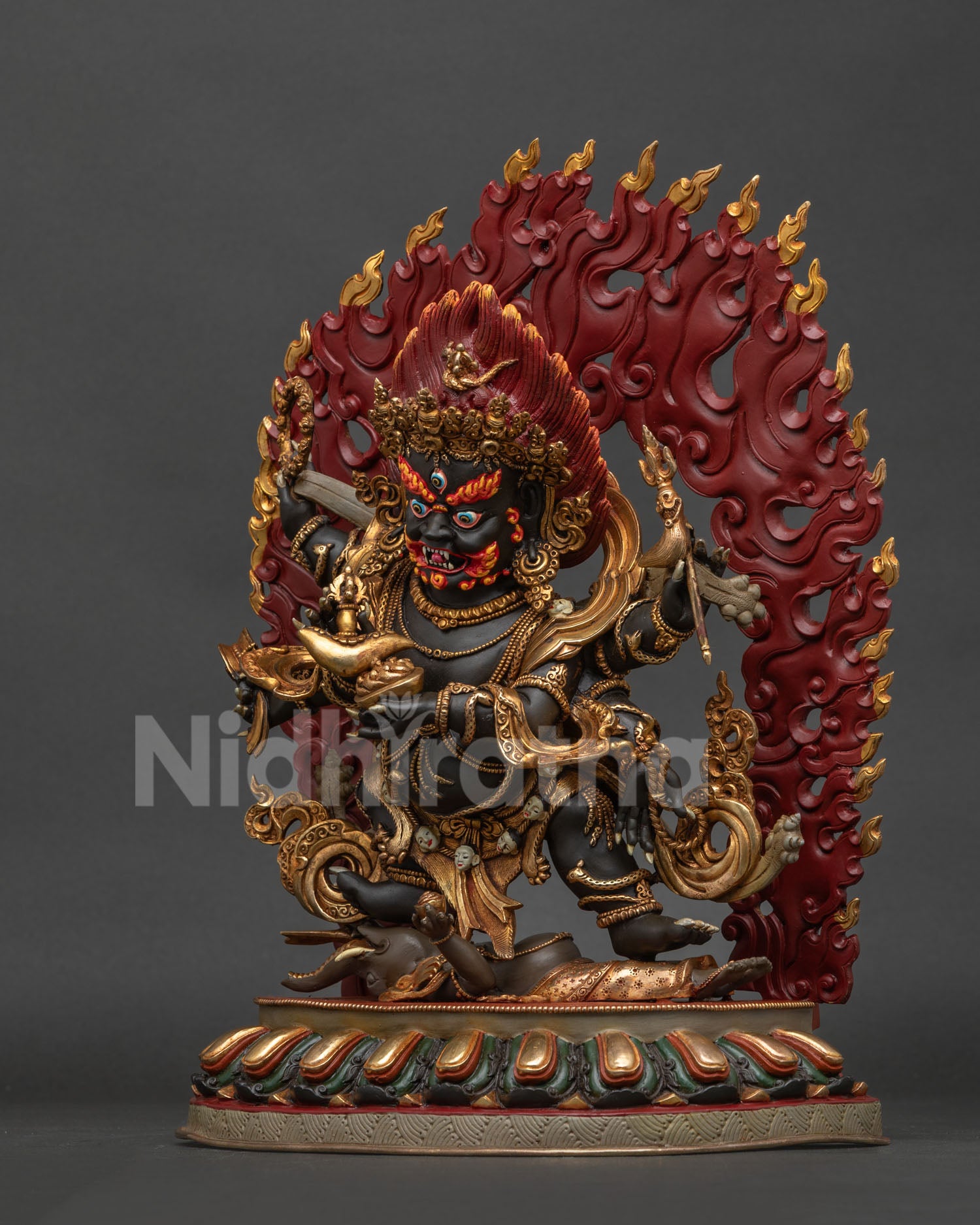 Six-armed Mahakala statue left side, highlighting the skull crown, flowing robes, and a blazing halo of wisdom fire.