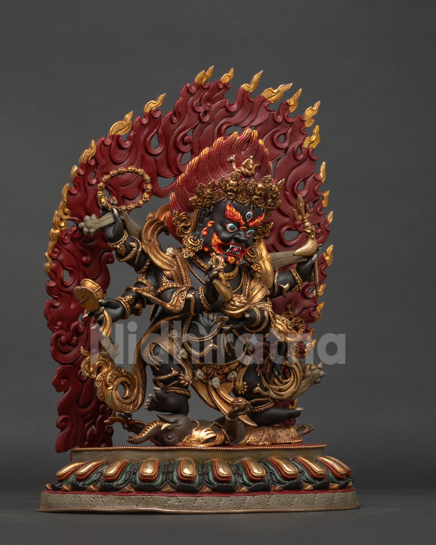 Six-armed Mahakala statue shown from the right side, depicting its wrathful protective form with a tiger skin draped across the body.