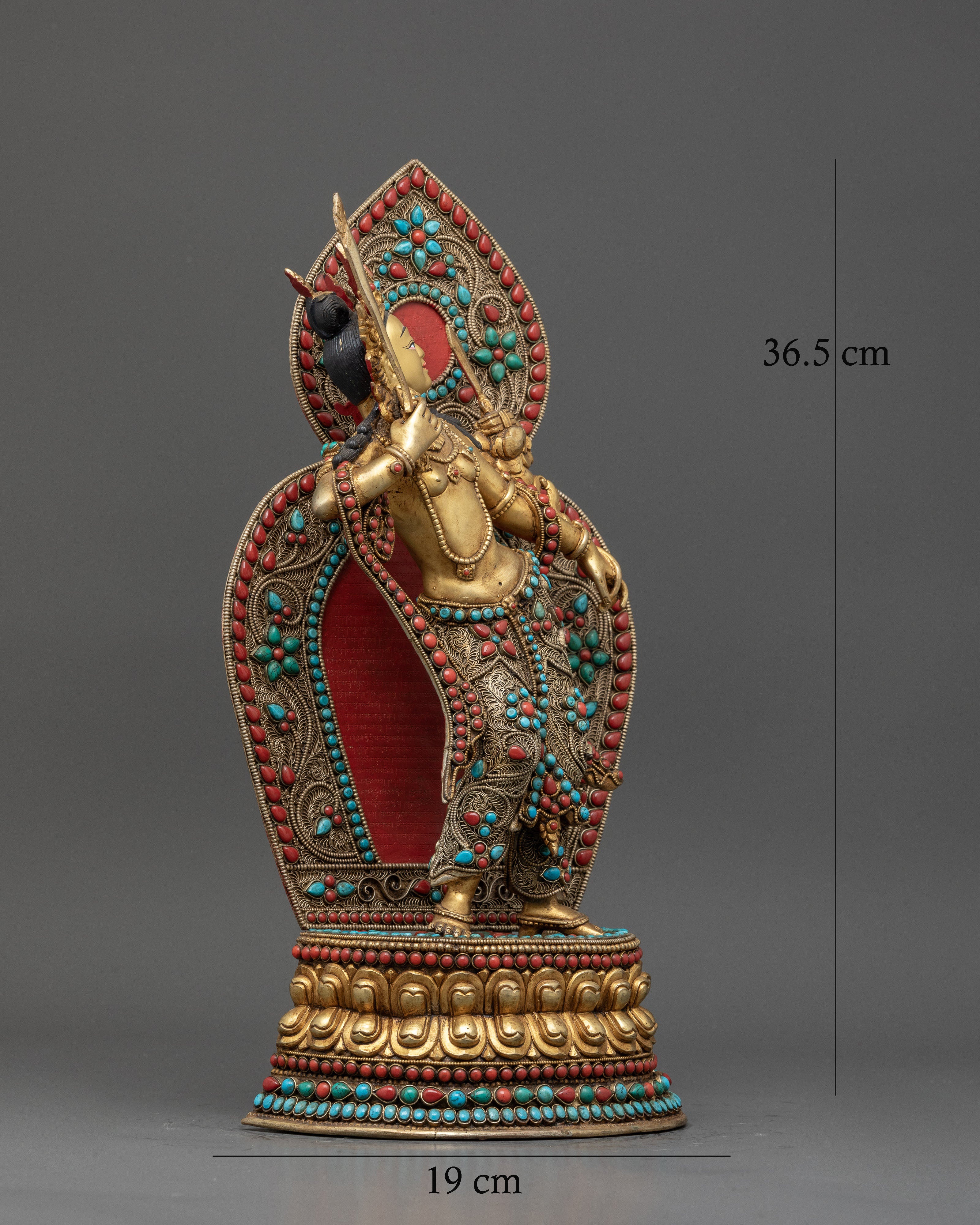 Standing Manjushri holding flaming sword and lotus with prajnaparamita sutra.