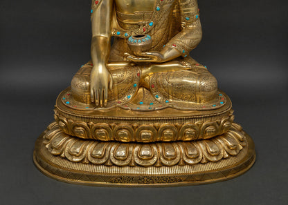 Three-quarter angle of Buddha statue on lotus base with mantra inscription