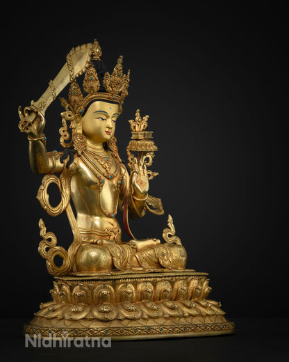 Three-quarter side view of gold fire-gilded Manjushri statue with raised sword and lotus seat