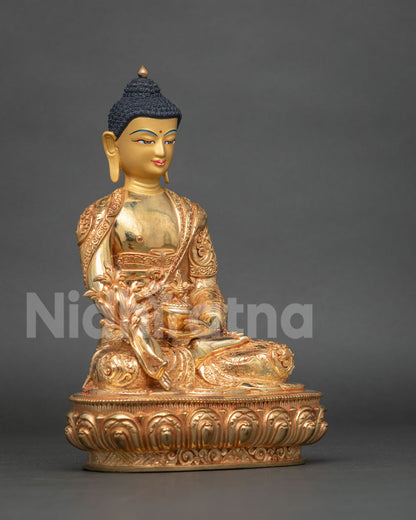 Three-quarter side view of gold Medicine Buddha statue on carved lotus pedestal