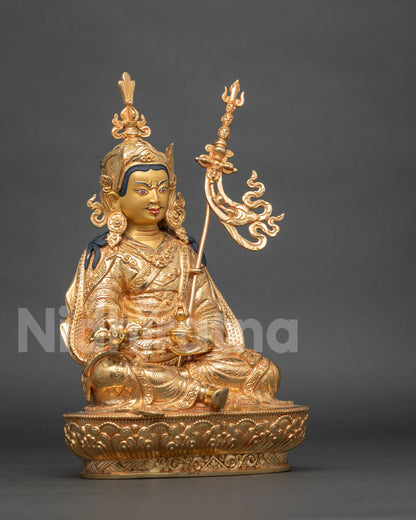 Three-quarter side view of gold Padmasambhava statue with kasaya robe and carved lotus seat