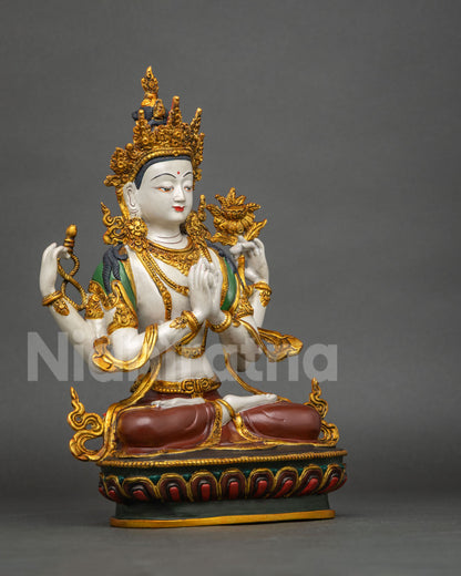 Three-quarter side view of hand-painted Chenrezig statue with gold lotus flower in hand