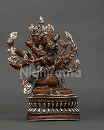 Three-quarter side view of handcrafted copper Guhyasamaja Yab-Yum statue with silver accents
