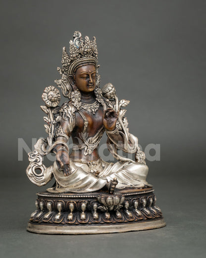 Three-quarter side view of seated Green Tara copper statue with oxidized brown patina