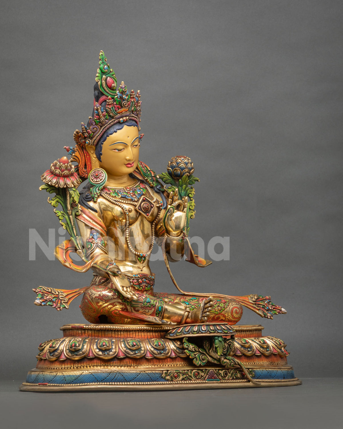 Three-quarter view of gold Green Tara sculpture seated in Lalitasana on a hand-painted lotus base