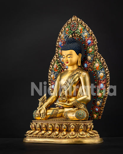 Three-quarter view of Medicine Buddha with colorful gemstone halo and gilded robes, Newari craftsmanship