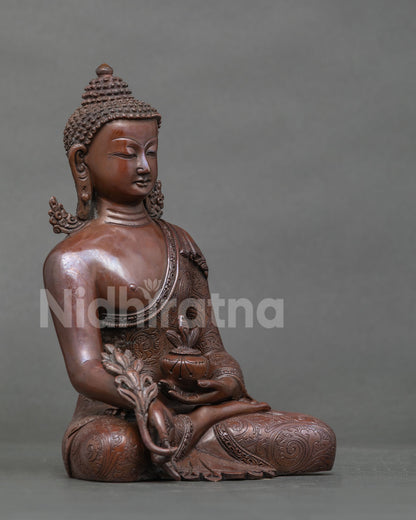 Three-quarter view of oxidized copper Bhaisajyaguru statue with myrobalan plant in hand