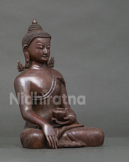Three-quarter view of oxidized copper Shakyamuni Buddha statue holding a patra bowl