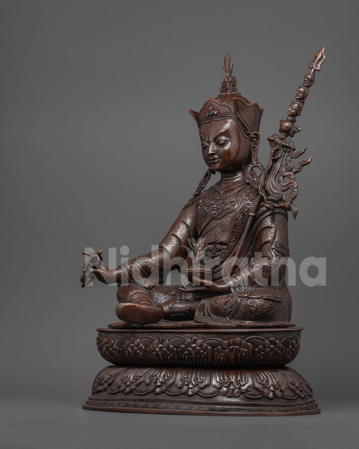 Three-quarter view of oxidized Guru Rinpoche statue holding vajra and skull cup, Nepal