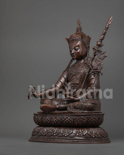 Three-quarter view of oxidized Guru Rinpoche statue holding vajra and skull cup, Nepal