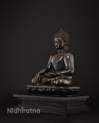 Three-quarter view of Shakyamuni Buddha statue in bhumisparsa mudra, cast in solid copper, Nepal