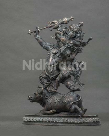 Three-quarter view of Yamantaka Vajrabhairava bronze statue showing dynamic stance on buffalo