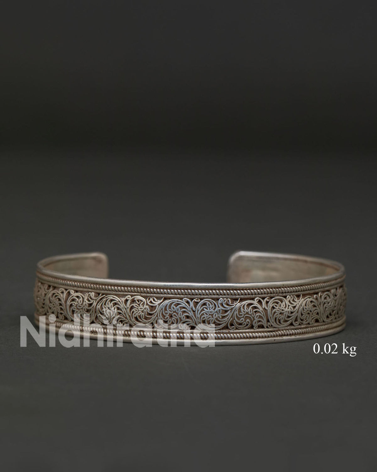 Tibetan-style silver bracelet with intricate filigree and flowing vine patterns