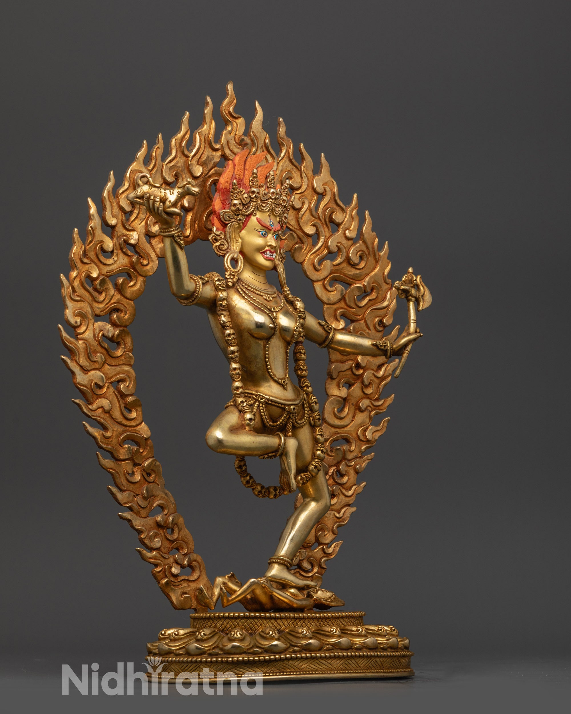 tibetan dorje phagmo statue side view with wrathful stance and blazing halo backdrop

