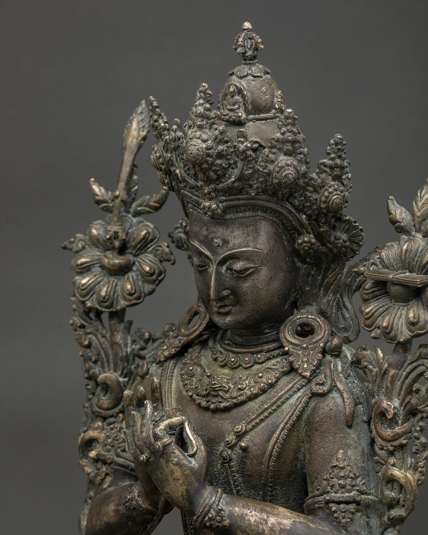tikshna manjushri statue face details with flaming sword and sutra close up