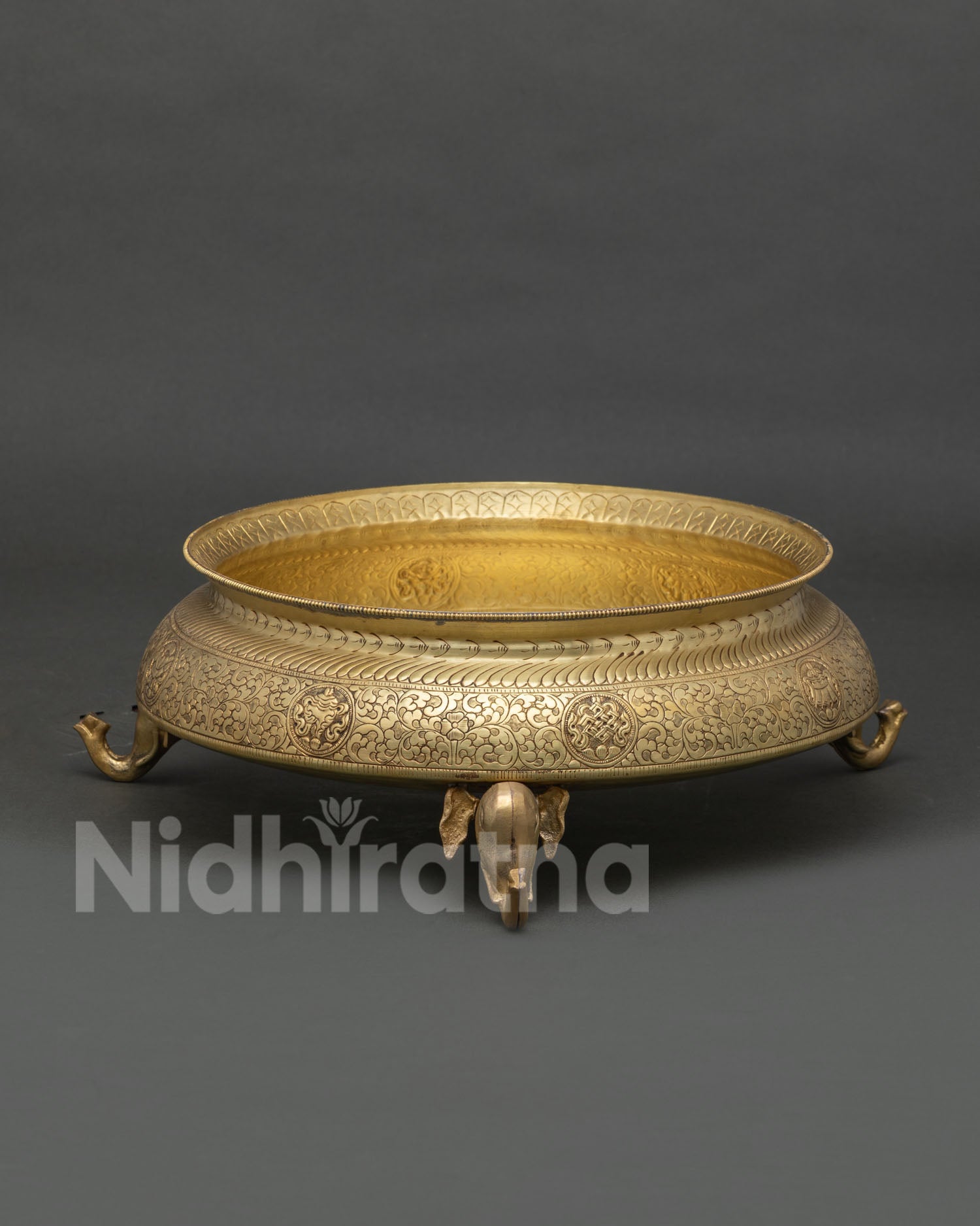 Traditional brass Urli Bowl with elephant stands and detailed Himalayan engravings