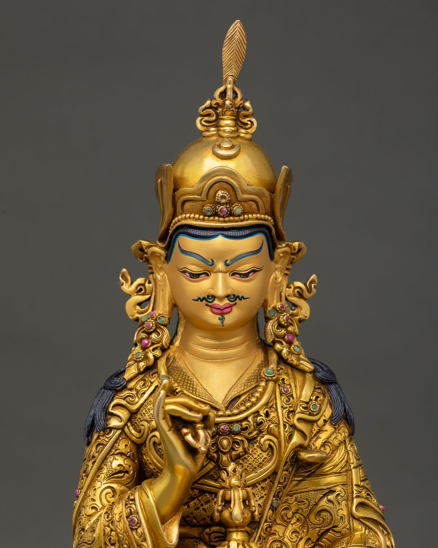 Tsokye Dorje sculpture, featuring a gold painted face and intricate three dimensional carvings