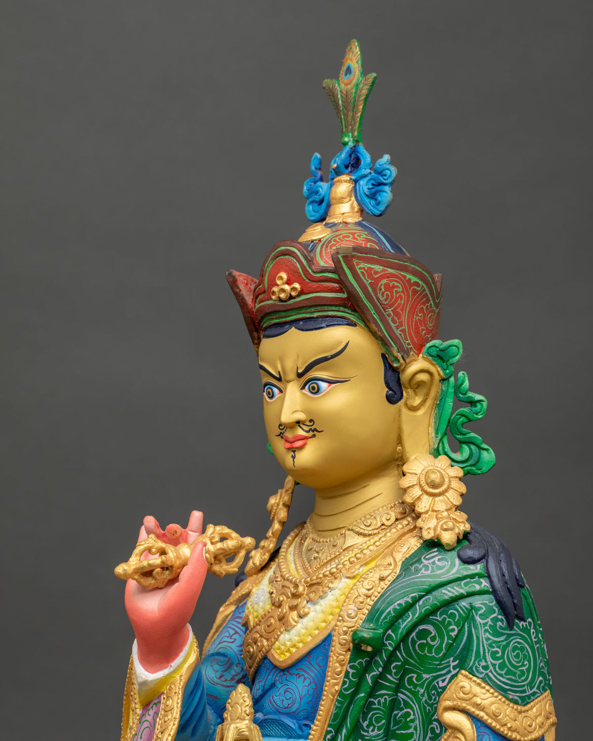 Tsokye Dorje statue featuring a traditional khatvanga staff with a trident and three heads resting against his shoulder.